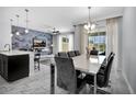 Elegant dining area featuring modern lighting and seamless open-concept layout to the living room at 8961 Cabot Cliffs Dr, Davenport, FL 33896