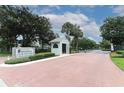 The Pine Ridge Club Village entrance features a guard house, a sign, and lush landscaping at 1221 S Pine Ridge Cir # A2, Sanford, FL 32773