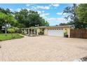 Paved driveway leading to a two-car garage, complemented by tropical landscaping and mature trees at 1405 Montclair Ct, Orlando, FL 32812