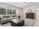 Cozy living room featuring a neutral sofa, tile flooring, and bright natural light from large windows at 1405 Montclair Ct, Orlando, FL 32812