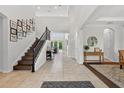 Bright foyer with soaring ceilings, tile floors, staircase, and views of the living areas at 15318 Sandfield Loop, Winter Garden, FL 34787