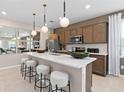 Modern kitchen featuring a quartz countertop island with pendant lighting and stainless appliances at 2025 Tohoqua Blvd, Kissimmee, FL 34744