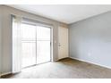 Bright living room features a sliding glass door to the balcony and neutral carpet at 2520 Caper Ln # 206, Maitland, FL 32751