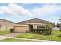 Attractive single-story home featuring a brick driveway, manicured lawn, and tidy landscaping at 267 Williamson Dr, Davenport, FL 33897