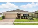 Inviting single-story home with well-maintained lawn, landscaping and two car garage at 267 Williamson Dr, Davenport, FL 33897