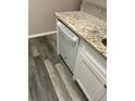 Modern white dishwasher with granite countertop and gray wood-look flooring at 2776 Curry Ford Rd # Ge, Orlando, FL 32806