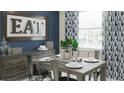 Eat sign over rustic dining room set with decorative blue print curtains at 3005 Namaste Dr, Clermont, FL 34714