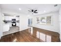 Bright living room featuring hardwood floors, modern ceiling fan, and an open view into the remodeled kitchen at 3007 Knollwood Cir, Orlando, FL 32804
