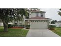 Inviting two-story home featuring a two-car garage and well-maintained front lawn landscaping at 3222 Reserve Ct, Orlando, FL 32825