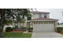 Inviting two-story home featuring a two-car garage and well-maintained front lawn landscaping at 3222 Reserve Ct, Orlando, FL 32825