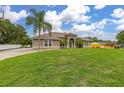Inviting single-story home with lush green lawn and mature palm trees in a serene setting at 3779 N Econlockhatchee Trl, Orlando, FL 32817