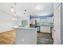 Open concept kitchen featuring stainless steel appliances, white cabinets, and a peninsula island at 395 Alcazar Ave, De Leon Springs, FL 32130