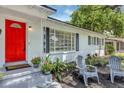 Inviting entrance with a vibrant red door, neat landscaping, and charming seating at 441 S Primrose Dr, Orlando, FL 32803