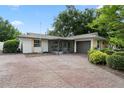 Rear view of home featuring decorative brick driveway and mature landscaping at 501 Benedict Ct, Casselberry, FL 32707
