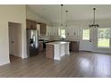 Stylish kitchen with white and wood cabinets, stainless appliances, island and modern pendant lighting at 524 Marion Oaks Blvd, Ocala, FL 34473