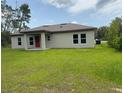 Rear exterior of house features a neutral paint scheme, manicured lawn, and access to outdoor enjoyment at 524 Marion Oaks Blvd, Ocala, FL 34473