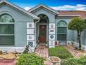 Inviting front entrance showcasing detailed stonework, a decorative door, and lush landscaping at 6902 Coral Cove Dr, Orlando, FL 32818