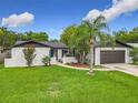 Charming single-Gathering home showcasing a well-maintained lawn, beautiful trees and attached garage at 8676 Hillside Dr, Orlando, FL 32810