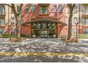 Stylish building entrance featuring an arched canopy, glass doors, and well-maintained landscaping at Uptown Place at 911 N Orange Ave # 440, Orlando, FL 32801