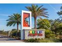 Community sign with palm trees, lush landscaping, and inviting entrance to the neighborhood at 11288 Listening Dr, Orlando, FL 32832