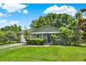 Charming one-story home with lush green lawn, mature landscaping, and a black front door at 1210 Quintuplet Dr, Casselberry, FL 32707