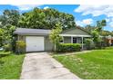 Charming one-story home with a lush green lawn and concrete driveway leading to the garage at 1210 Quintuplet Dr, Casselberry, FL 32707