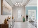 Inviting foyer featuring tiled flooring, a modern chandelier, decorative artwork, and an open doorway to the living area at 1265 Estancia Woods Loop, Windermere, FL 34786