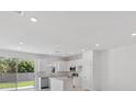 Bright, all-white kitchen with stainless steel appliances and a sliding door to the backyard at 1267 Stockwell Ave, St Cloud, FL 34771