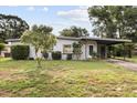 Single-story home with a covered carport and landscaped front yard showcasing mature trees at 137 W Lauren Ct, Fern Park, FL 32730