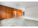 Spacious living room featuring unique wood paneling and a vintage ceiling fan at 137 W Lauren Ct, Fern Park, FL 32730