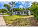 A single-story home with light blue paint, dark shutters, and a well-maintained lawn at 1417 Pine Lake Rd, Orlando, FL 32808