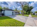 A single-story home with light blue paint, manicured lawn, and a paved driveway at 1417 Pine Lake Rd, Orlando, FL 32808