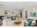 Bright and airy living room with a view of the patio, open floorplan, modern furnishings, and light wood floors at 14470 Sw 46Th Ct, Ocala, FL 34473