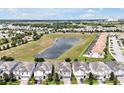 An aerial view showcases a neighborhood, a scenic pond, and green spaces in the background at 1521 Flange Dr, Davenport, FL 33896
