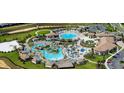 An aerial view displays a resort-style pool, sun loungers, cabanas, and lush landscaping at 1521 Flange Dr, Davenport, FL 33896