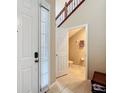 Bright entryway featuring a staircase with wood and wrought iron, adjacent to a half bathroom at 15822 Woodland Spring Ct, Orlando, FL 32828