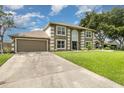 Two-story house featuring a spacious driveway, lush lawn, and decorative trimmed windows at 16012 Lanesboro Ct, Clermont, FL 34711