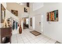 Bright foyer featuring a two-story ceiling, tiled floor, and staircase at 16012 Lanesboro Ct, Clermont, FL 34711