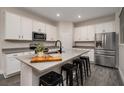 Modern kitchen with white cabinets, gray countertops, stainless steel appliances, and a breakfast bar at 1624 Little Wren Ln, Winter Park, FL 32792