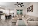 Open-concept living area with a sectional couch, modern fan, and breakfast bar leading to the kitchen at 1624 Little Wren Ln, Winter Park, FL 32792