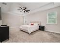 Spacious main bedroom featuring tray ceilings, plush carpeting, two windows for natural light, and a serene atmosphere at 1624 Little Wren Ln, Winter Park, FL 32792