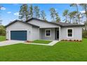 Beautiful single-story home boasts a well-kept lawn and landscaping, complemented by a modern, eye-catching blue garage door at 17397 Sw 41St Cir, Ocala, FL 34473