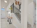 Elegant entryway featuring a staircase with black iron railings, a tiled floor, and a stylish console table at 2105 Lake Side Ave, Davenport, FL 33837