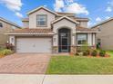 Charming two-story home with a brick-paved driveway and well-kept lawn in a sunny neighborhood at 2105 Lake Side Ave, Davenport, FL 33837