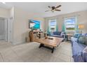 Bright living room featuring tile floors, a ceiling fan, large windows, and modern furniture at 2105 Lake Side Ave, Davenport, FL 33837