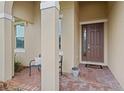 Inviting front porch with brick pavers, decorative columns, and a cozy bench, perfect for relaxing at 2339 Jernigan Loop, Kissimmee, FL 34746