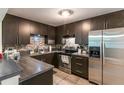 Modern kitchen featuring stainless steel appliances, dark brown cabinets, and sleek countertops at 3410 Calumet Dr, Orlando, FL 32810