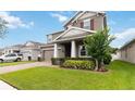 Beautiful two-story home with a well-maintained lawn, brick-paved driveway, and covered front entrance at 4759 Riverwalk Dr, St Cloud, FL 34771