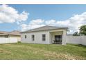 Spacious backyard with lush green grass and a cozy covered patio, great for outdoor activities at 504 Key Haven Dr, Sanford, FL 32771