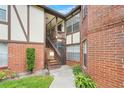 Charming exterior featuring a well-maintained brick facade, wooden staircase, and lush landscaping at 5323 Hansel Ave # E14, Orlando, FL 32809